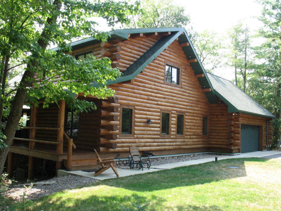 Idée de décoration pour une façade de maison marron chalet en bois de taille moyenne et à un étage avec un toit à deux pans et un toit en shingle.