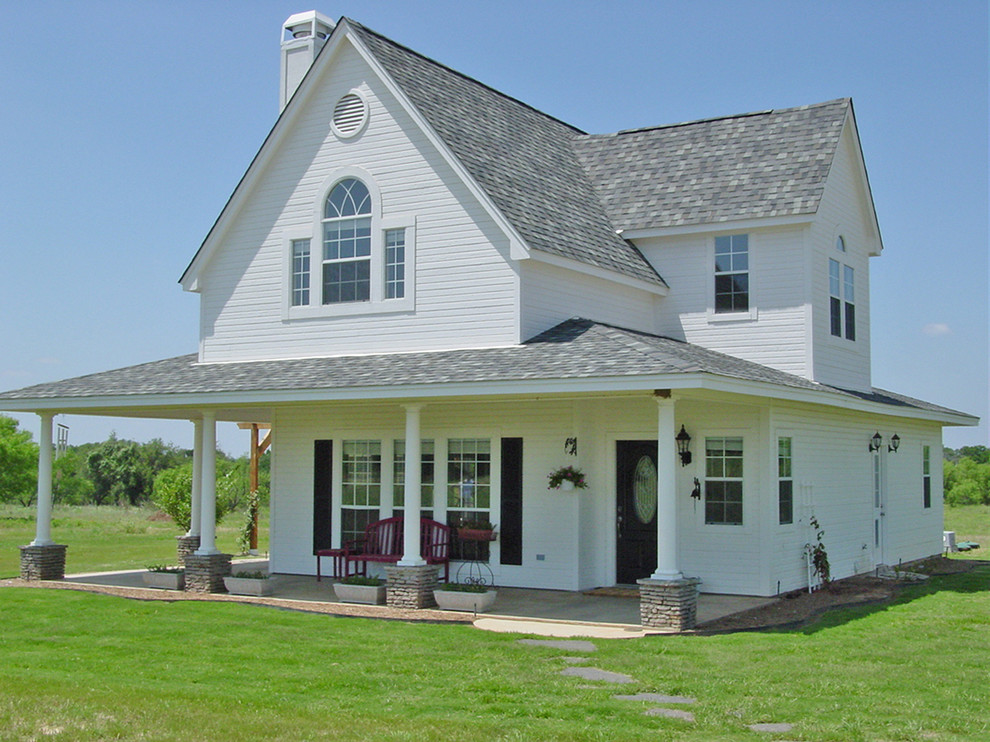 Esempio della facciata di una casa piccola bianca country a due piani con rivestimento con lastre in cemento e tetto a capanna