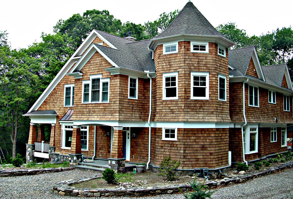Ejemplo de fachada de casa marrón de estilo americano grande de dos plantas con revestimiento de madera, tejado a doble faldón y tejado de teja de madera