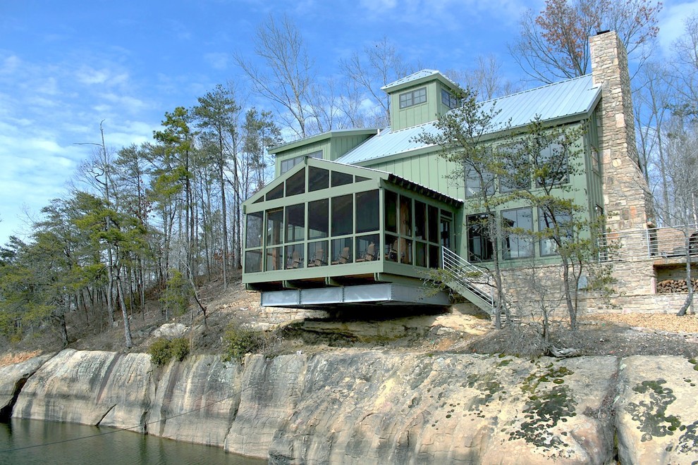 Cette image montre une façade de maison verte chalet à un étage.