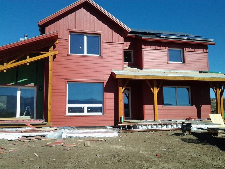 Exemple d'une façade de maison rouge nature en panneau de béton fibré de taille moyenne et à un étage.