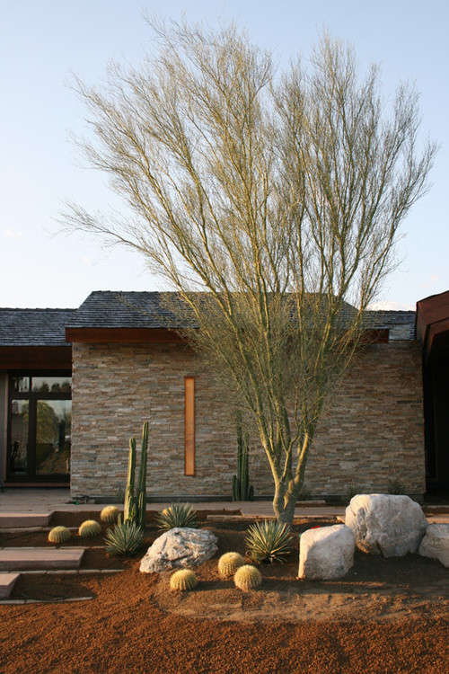 Réalisation d'une grande façade de maison beige design en pierre de plain-pied avec un toit à deux pans.