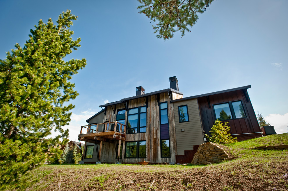 На фото: трехэтажный, серый частный загородный дом среднего размера в современном стиле с комбинированной облицовкой, односкатной крышей и металлической крышей