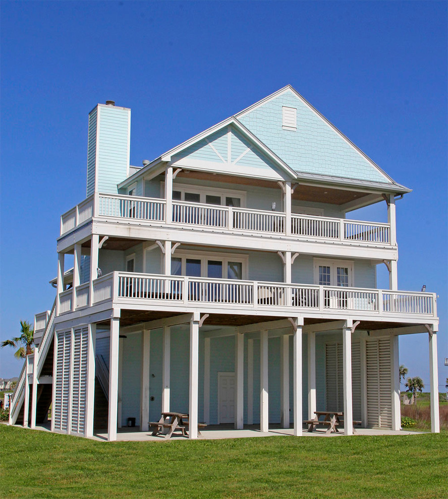 Réalisation d'une façade de maison bleue marine en bois de taille moyenne et à un étage avec un toit à deux pans.
