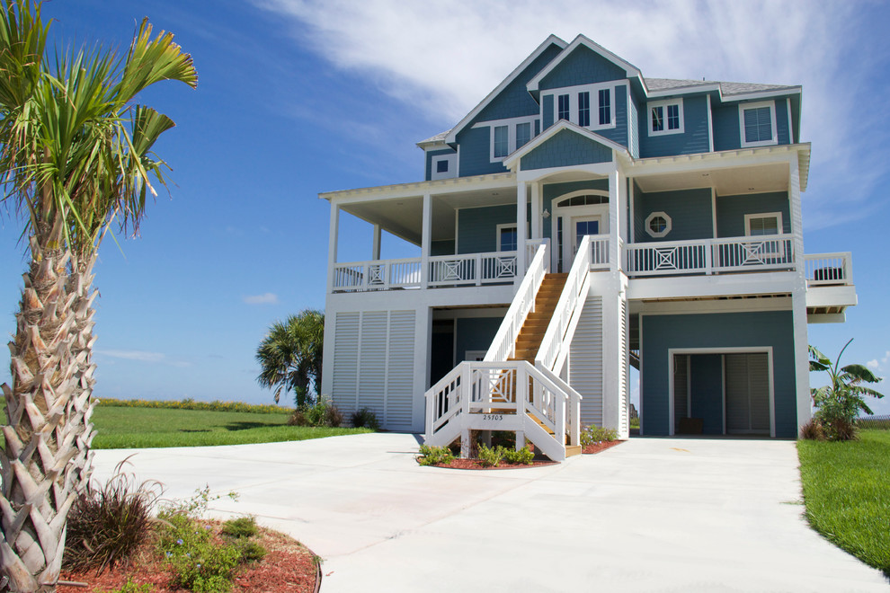Cette photo montre une grande façade de maison bleue bord de mer en panneau de béton fibré à deux étages et plus avec un toit à deux pans.