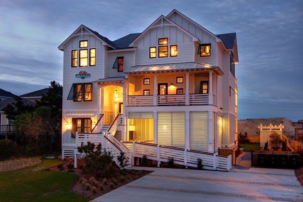 Cette image montre une grande façade de maison blanche marine à deux étages et plus avec un revêtement en vinyle et un toit à deux pans.