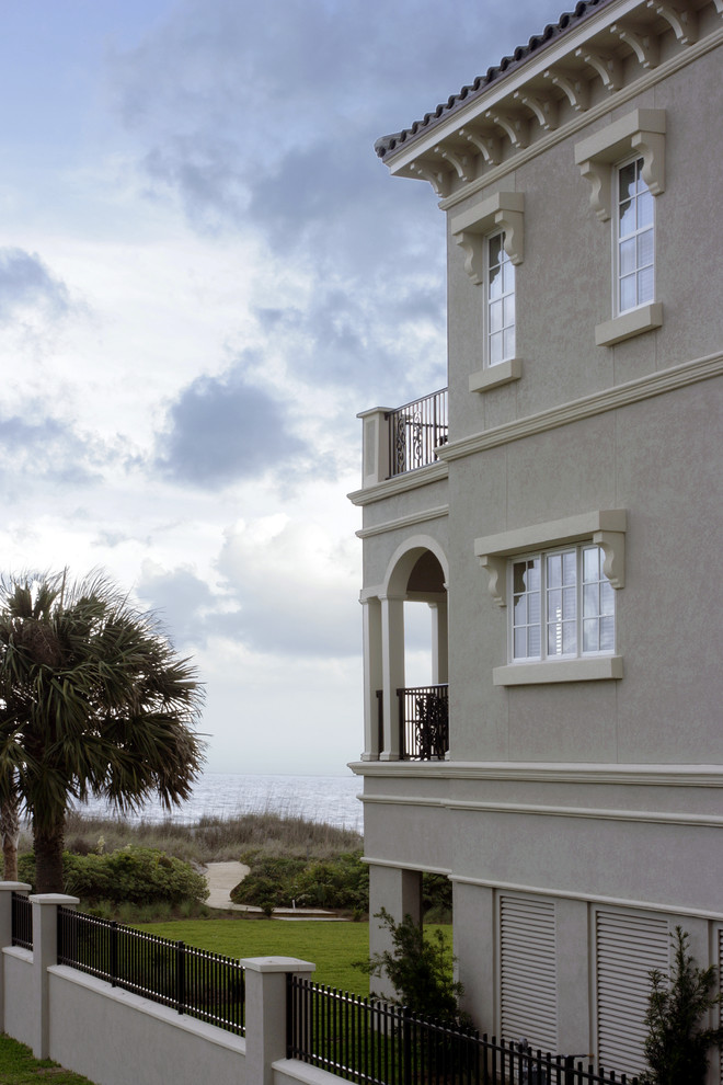 Großes, Dreistöckiges Mediterranes Haus mit Putzfassade, grauer Fassadenfarbe und Satteldach in Charleston