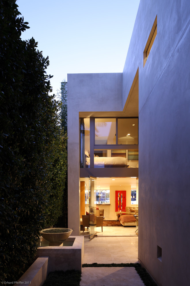 На фото: большой, двухэтажный, серый частный загородный дом в современном стиле с облицовкой из бетона и плоской крышей