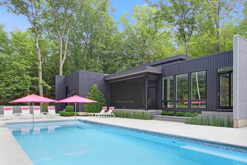Idée de décoration pour une grande façade de maison noire minimaliste en panneau de béton fibré à un étage avec un toit plat.