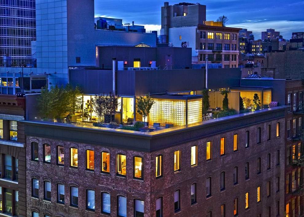 This is an example of an expansive and red modern brick flat in New York with a flat roof.