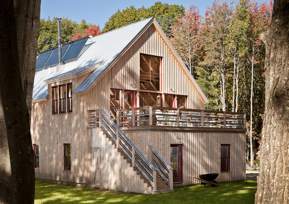 Ejemplo de fachada de casa beige clásica de dos plantas con revestimiento de madera, tejado a dos aguas y tejado de metal