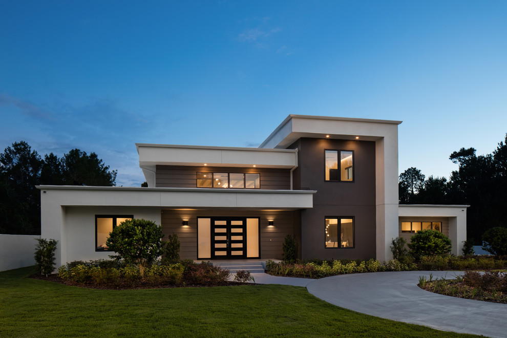 Cette photo montre une très grande façade de maison blanche moderne en stuc à un étage avec un toit plat et un toit végétal.