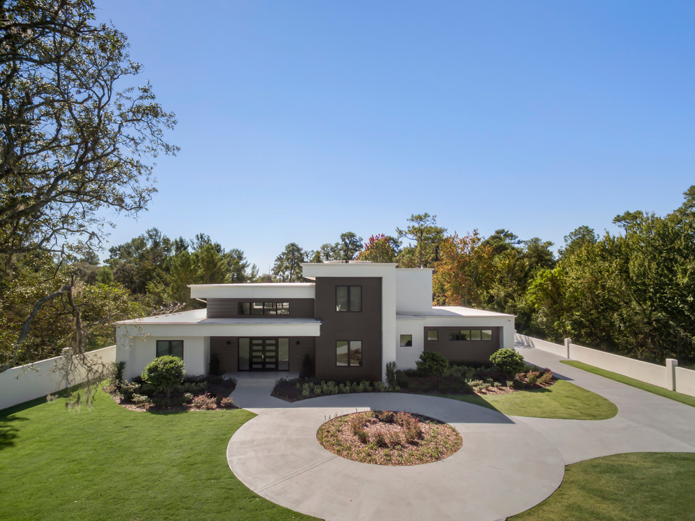 Стильный дизайн: огромный, двухэтажный, белый частный загородный дом в стиле модернизм с облицовкой из цементной штукатурки, плоской крышей и зеленой крышей - последний тренд