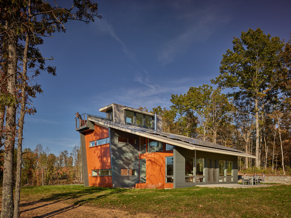 Foto de fachada de casa gris moderna de tamaño medio de tres plantas con revestimientos combinados, tejado a cuatro aguas y techo verde