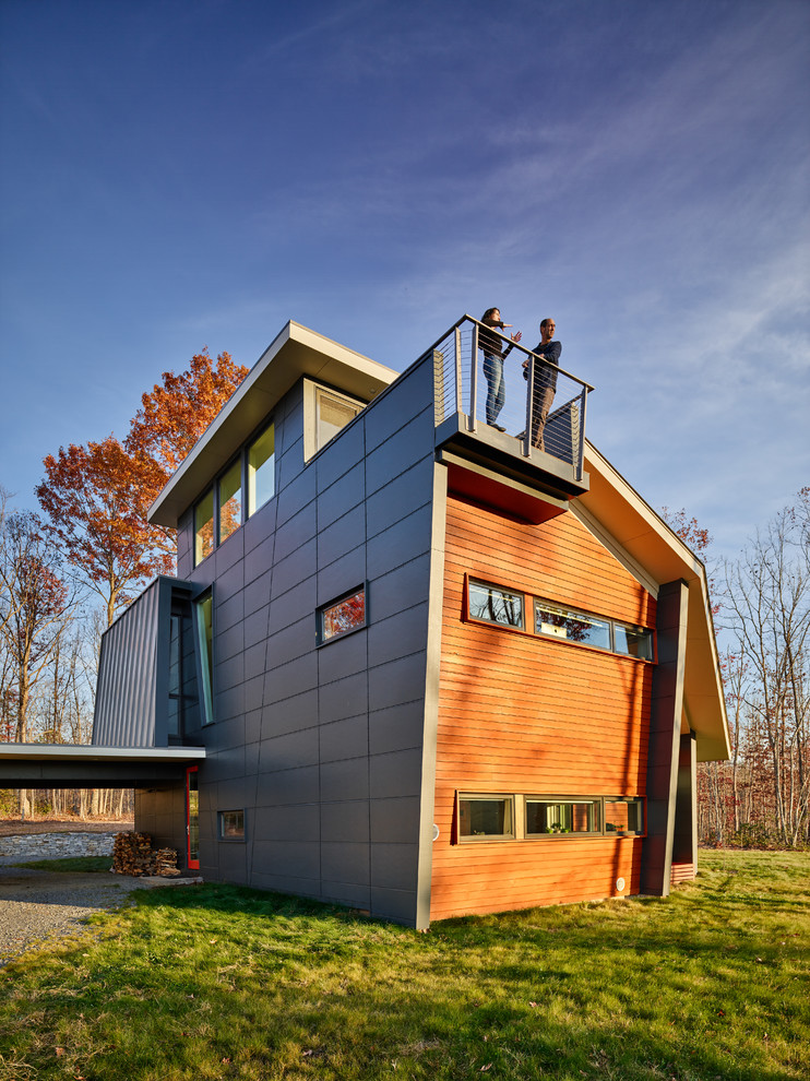 Foto på ett mellanstort funkis grått hus, med tre eller fler plan, blandad fasad, valmat tak och levande tak