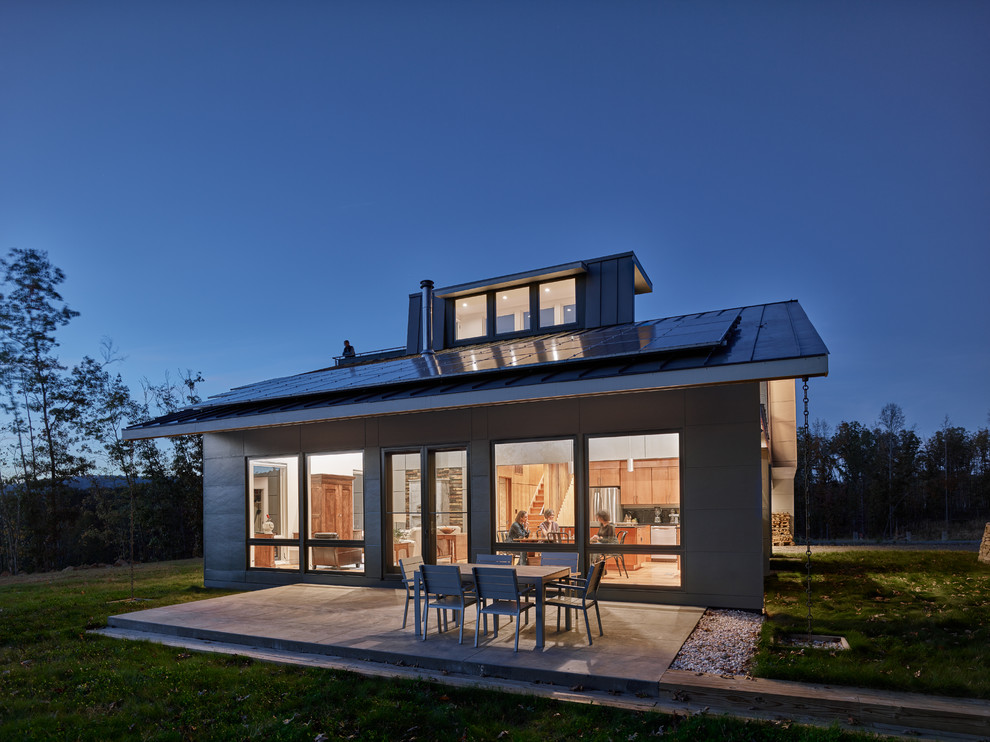 Foto de fachada de casa gris moderna de tamaño medio de tres plantas con revestimientos combinados, tejado a cuatro aguas y techo verde