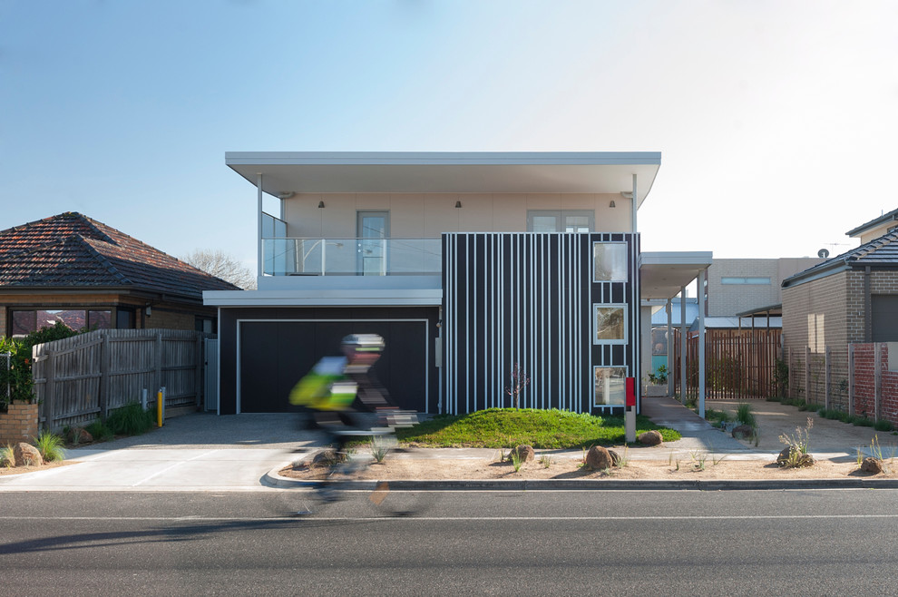 Mittelgroßes, Zweistöckiges Modernes Einfamilienhaus mit Metallfassade, beiger Fassadenfarbe, Flachdach und Blechdach in Melbourne