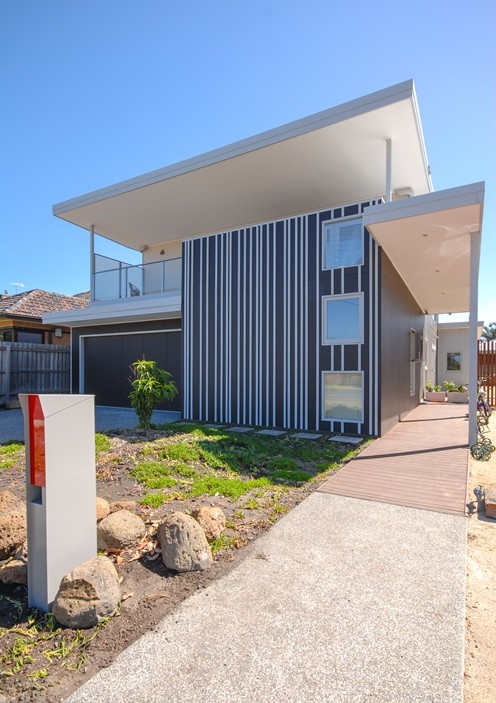 Mid-sized contemporary beige two-story metal exterior home idea in Melbourne with a metal roof