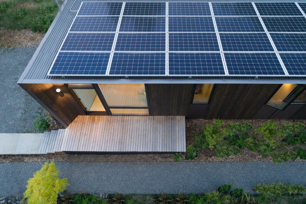 Inspiration pour un petite façade d'immeuble minimaliste en bois avec un toit plat et un toit mixte.