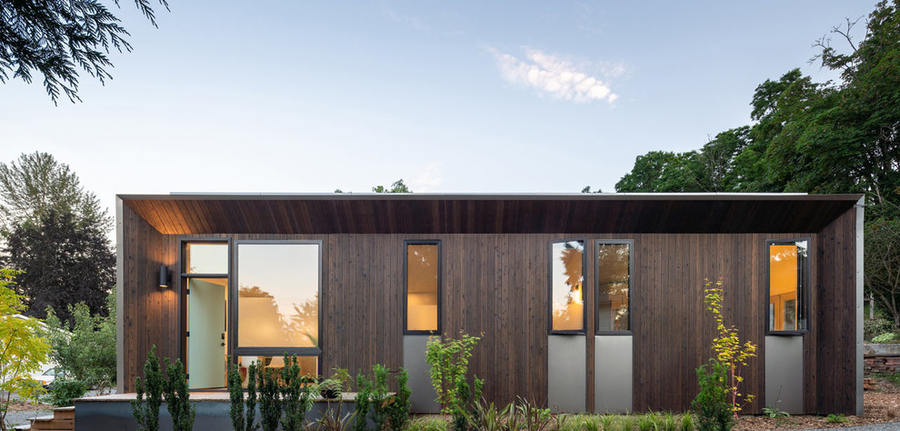 Источник вдохновения для домашнего уюта: маленький, одноэтажный, деревянный, коричневый многоквартирный дом в стиле модернизм с плоской крышей и крышей из смешанных материалов для на участке и в саду