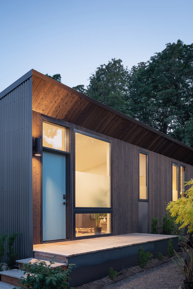 Idéer för ett litet modernt brunt hus, med allt i ett plan, platt tak och tak i mixade material