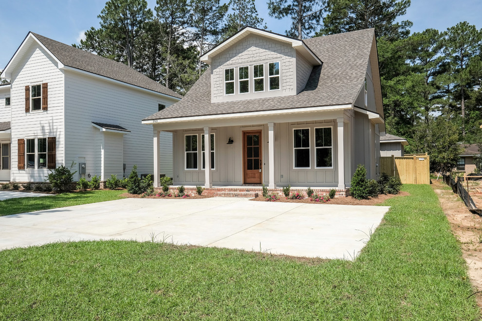 This is an example of a medium sized and gey country two floor detached house in New Orleans with concrete fibreboard cladding, a pitched roof and a shingle roof.