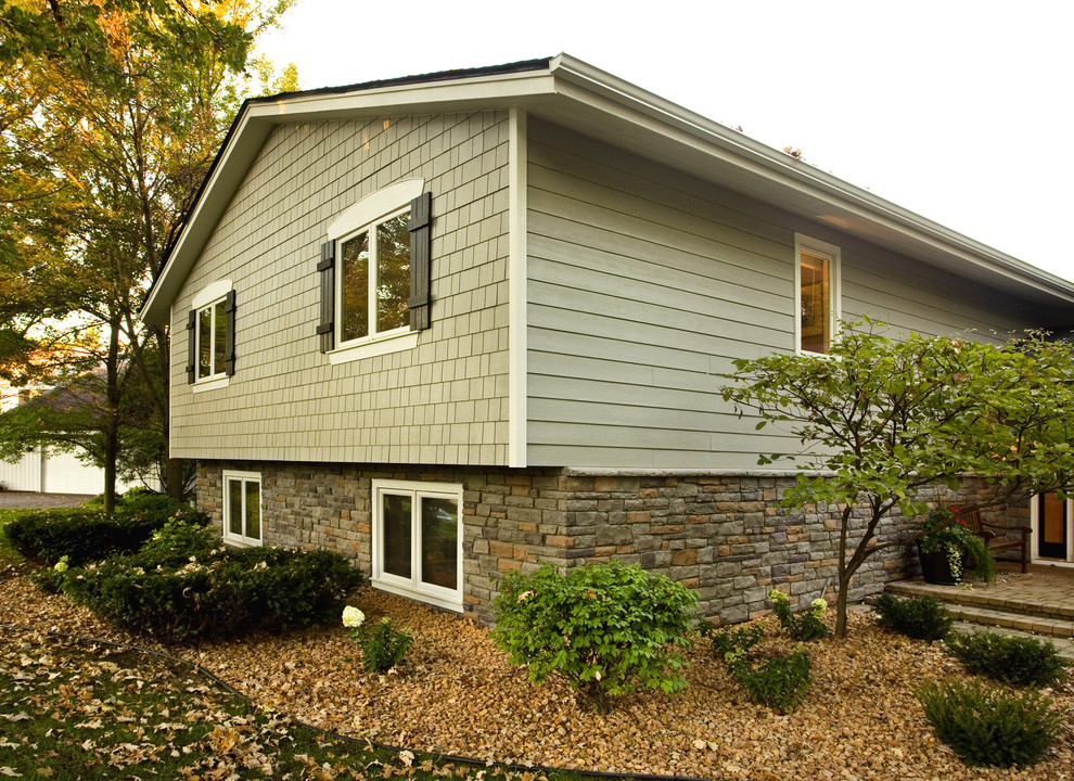 Exemple d'une façade de maison grise chic à niveaux décalés avec un revêtement mixte et un toit à deux pans.