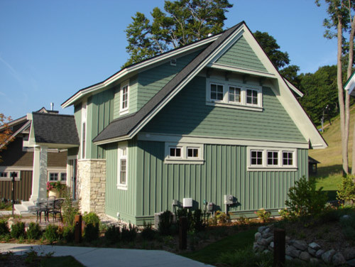 This is an example of a medium sized and green traditional bungalow house exterior in Grand Rapids with wood cladding.