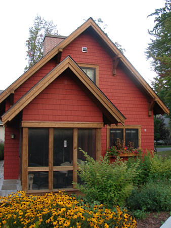 Foto della facciata di una casa rossa classica a un piano di medie dimensioni con rivestimento in legno