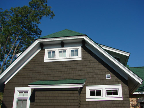 Foto della facciata di una casa piccola marrone classica a due piani con rivestimento in legno