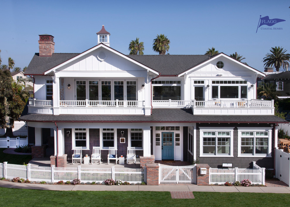Imagen de fachada de casa gris marinera grande de dos plantas con revestimientos combinados, tejado a dos aguas y tejado de teja de madera