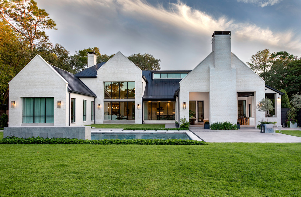 Zweistöckiges Klassisches Einfamilienhaus mit Backsteinfassade, weißer Fassadenfarbe und Satteldach in Houston