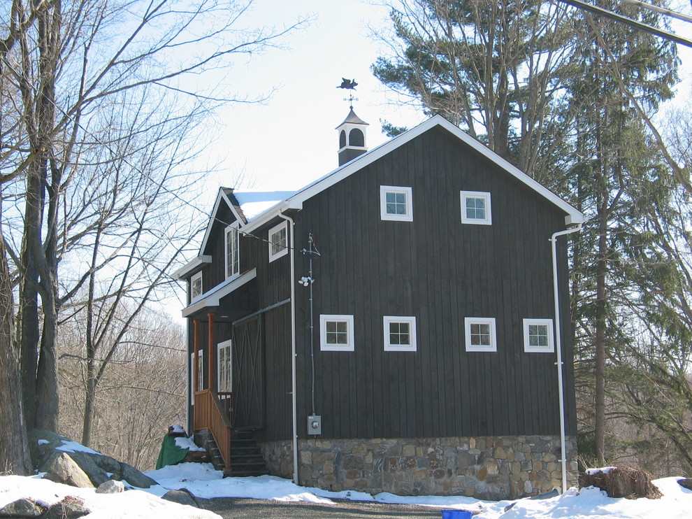 Modelo de fachada negra de estilo de casa de campo pequeña de tres plantas con revestimiento de madera y tejado a dos aguas