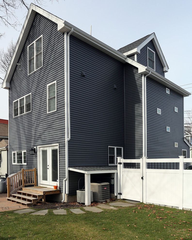 Exemple d'une façade de maison bleue moderne de taille moyenne et à deux étages et plus avec un revêtement en vinyle et un toit en appentis.