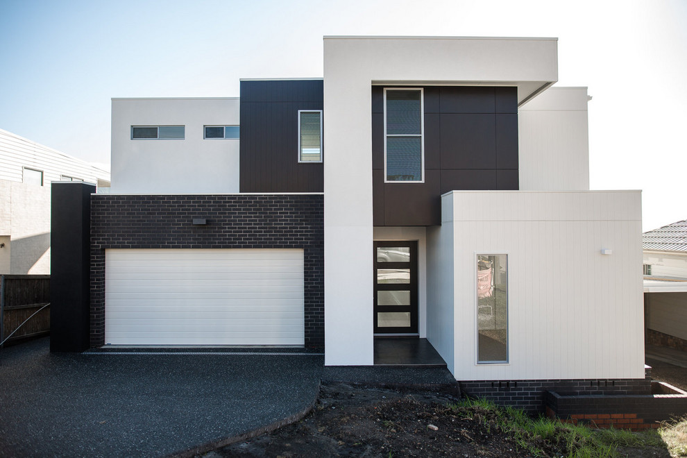 Modelo de fachada de casa multicolor minimalista pequeña de dos plantas con tejado plano y tejado de metal