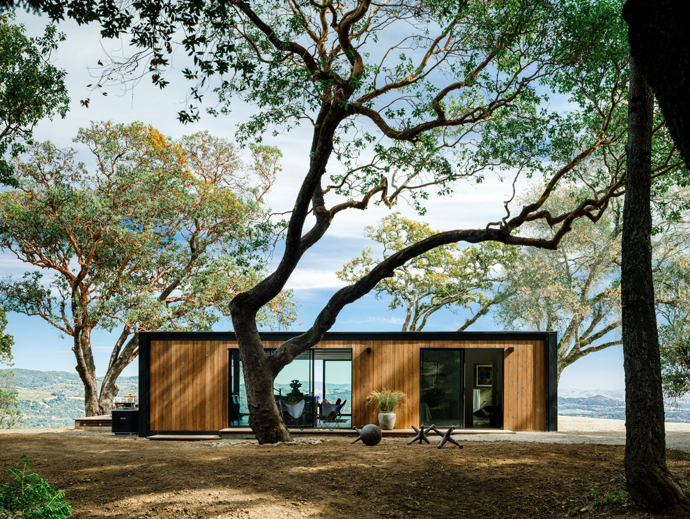 Inspiration pour une façade de maison marron minimaliste en bois de taille moyenne et de plain-pied avec un toit plat.