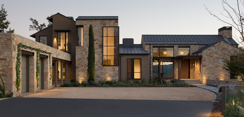 Immagine della facciata di una casa contemporanea a due piani con rivestimento in pietra
