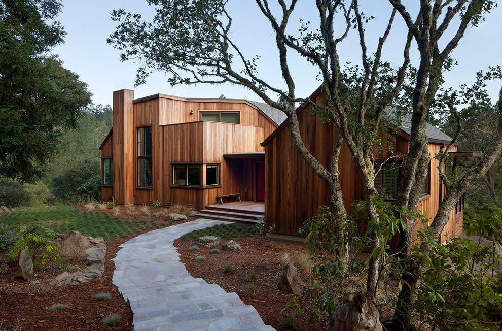 Diseño de fachada de estilo de casa de campo de dos plantas con revestimiento de madera y tejado a dos aguas