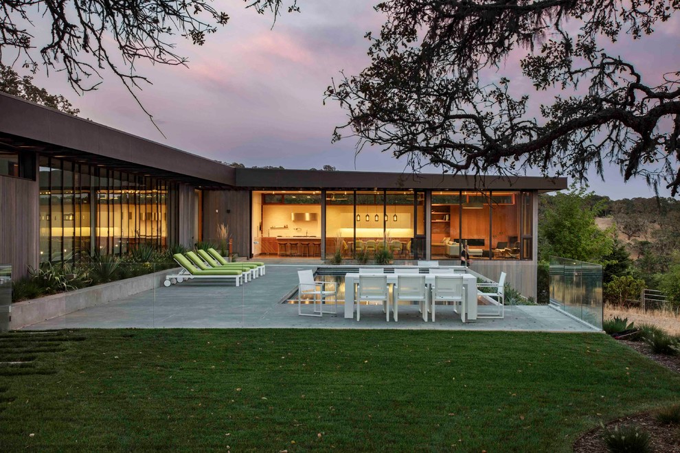 Diseño de fachada de casa gris minimalista grande de una planta con revestimiento de madera