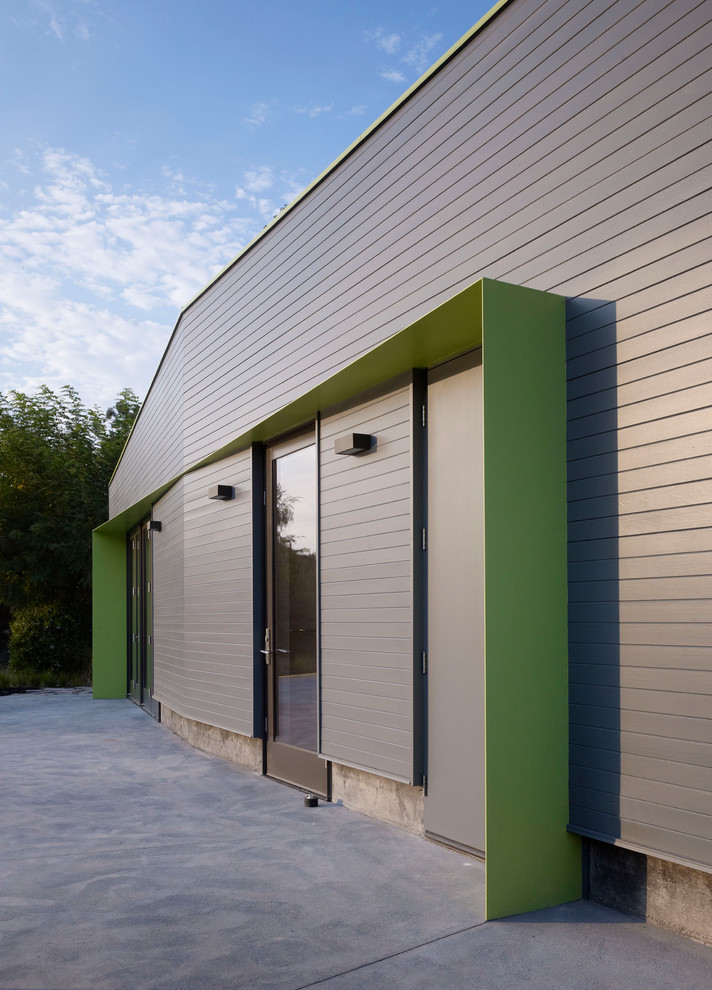 Imagen de fachada gris contemporánea pequeña de una planta con revestimiento de metal y tejado plano