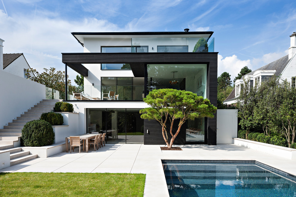 Стильный дизайн: трехэтажный, белый дом в современном стиле с плоской крышей - последний тренд