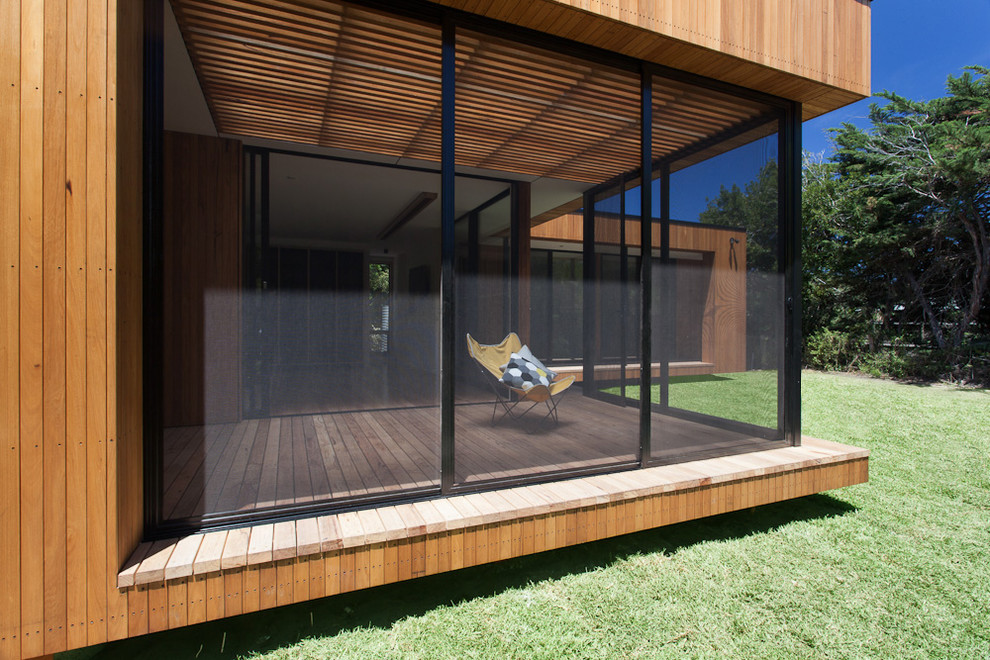 Inspiration pour une façade de maison marron minimaliste en bois de taille moyenne avec un toit plat.