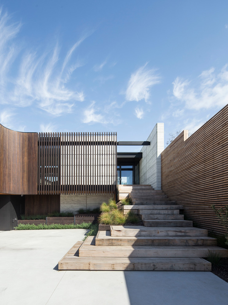 Inspiration pour une façade de maison grise design en béton à un étage avec un toit plat.
