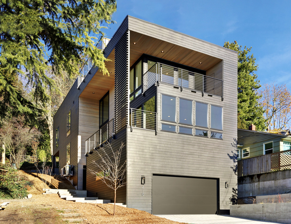 Ejemplo de fachada de casa negra actual de tamaño medio de tres plantas con revestimiento de aglomerado de cemento y tejado plano