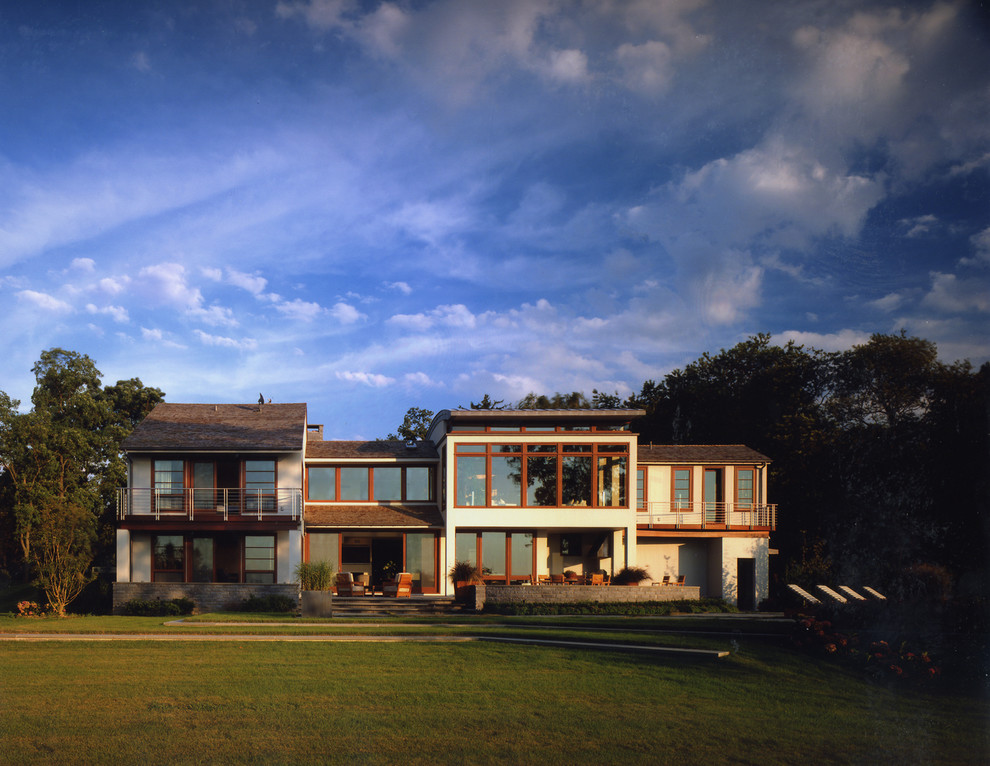 На фото: большой, двухэтажный, разноцветный частный загородный дом в современном стиле с комбинированной облицовкой, односкатной крышей и крышей из гибкой черепицы с