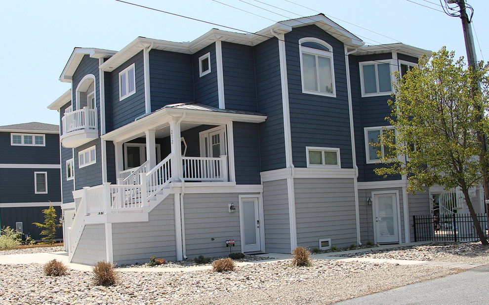 Exemple d'une très grande façade de maison bleue bord de mer en bois à deux étages et plus.