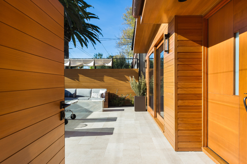 Exemple d'une façade de maison marron moderne en bois de taille moyenne et de plain-pied avec un toit en appentis.