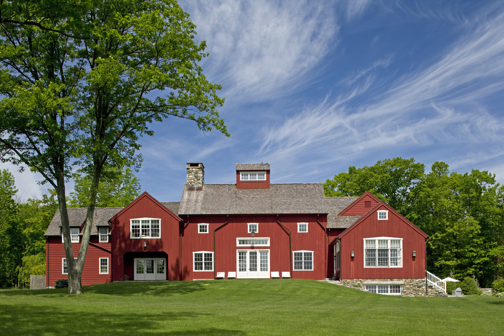 Immagine della facciata di una casa ampia rossa country a due piani con rivestimento in legno