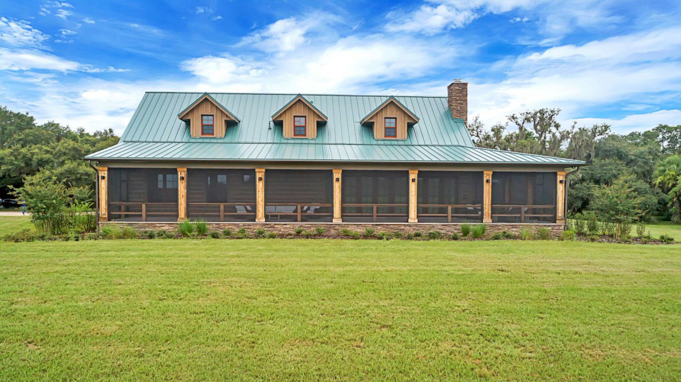 Foto de fachada de casa marrón rústica de tamaño medio de dos plantas con revestimiento de hormigón, tejado a dos aguas y tejado de metal