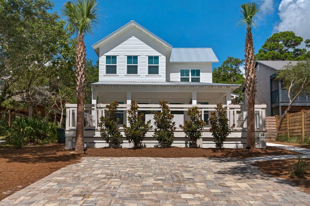 Inspiration for a large coastal white two-story wood exterior home remodel in Miami with a shingle roof